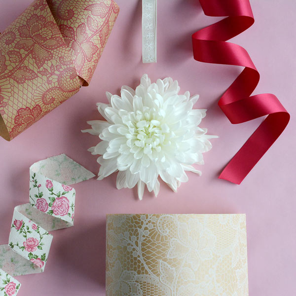 White flower surrounded by a variety of ribbons and wraps