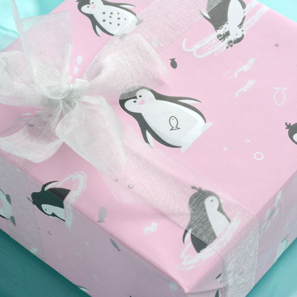 Cute penguins on pink wrapping paper with organza bow