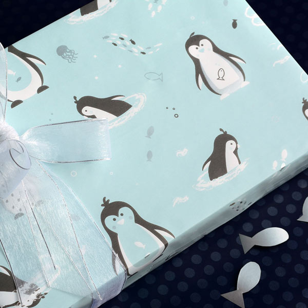 Cute penguins on blue wrapping paper with organza ribbon