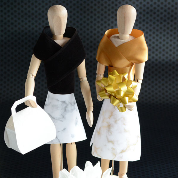 Wooden dummies dressed in ribbon and paper with bonbonniere handbag